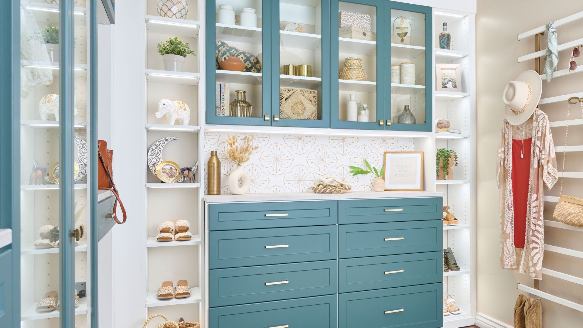 a walk in closet with lagoon cabinets and white shelves .