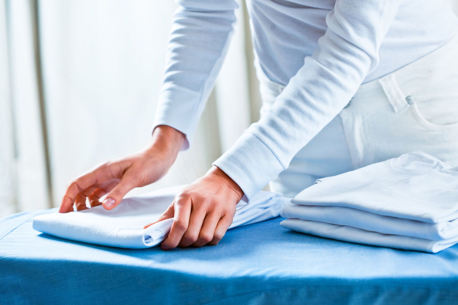 Woman Stacking Ironed Folded Shirts — Beatrice, NE — Soap Opera Laundry