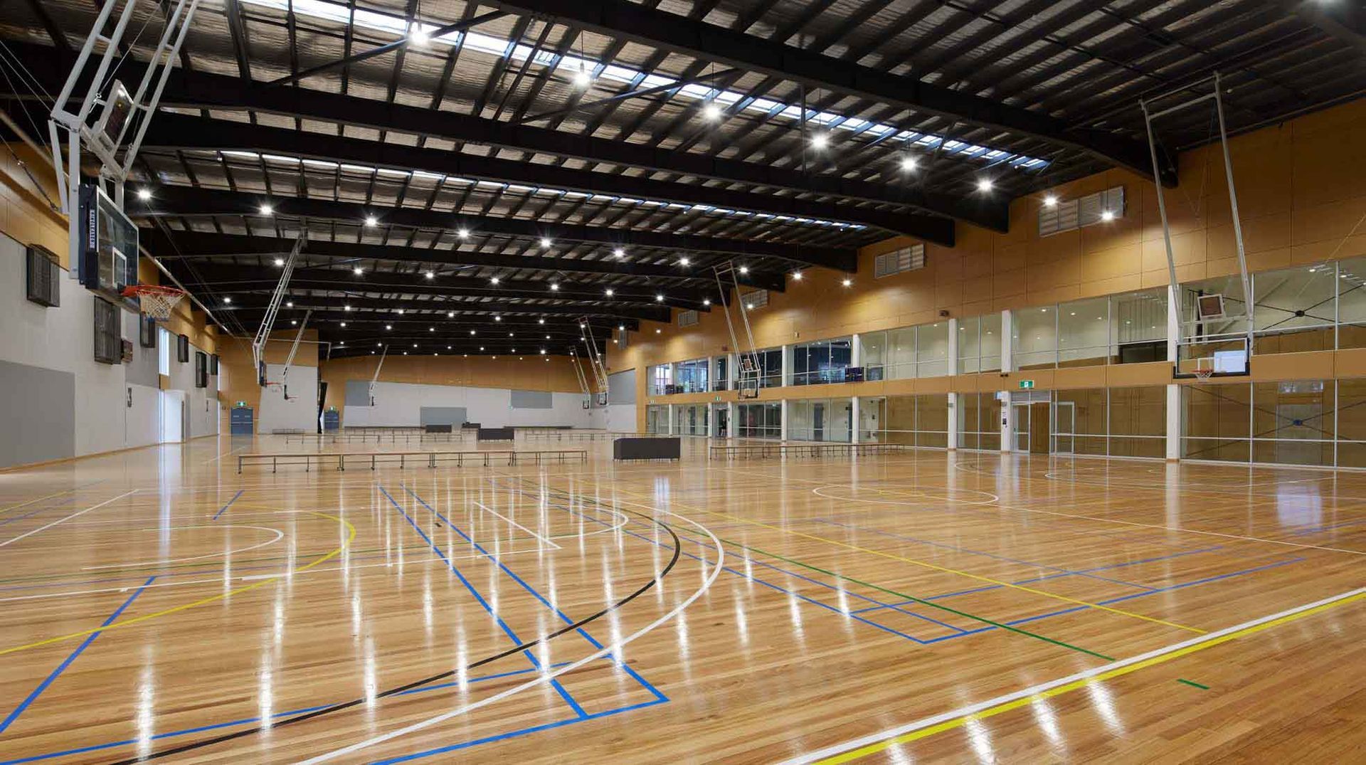 A large indoor basketball court with a wooden floor and a basketball hoop.
