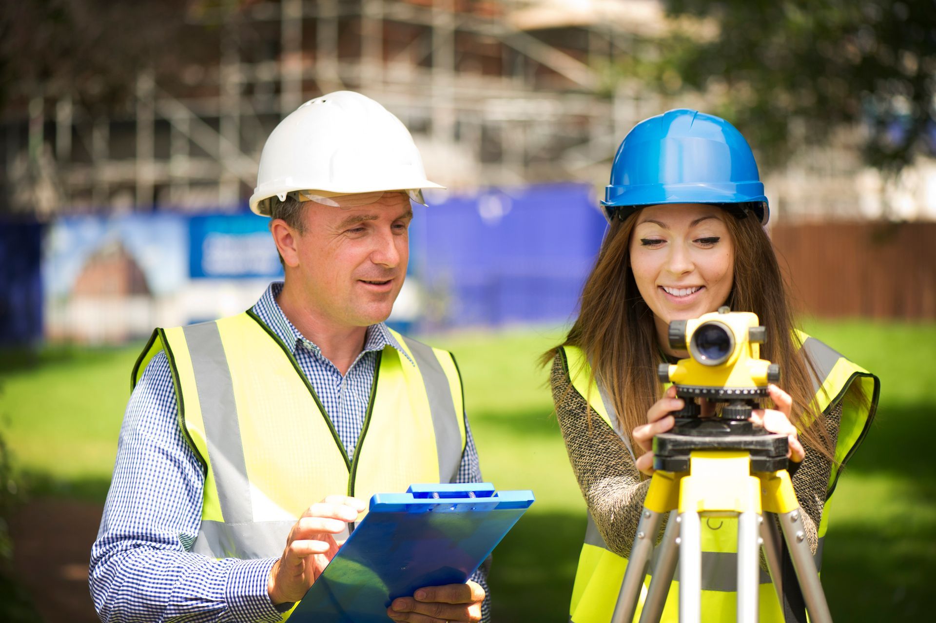 Construction surveying team discuss a tablet at a construction site. Construction surveying team discuss a tablet at a construction site.