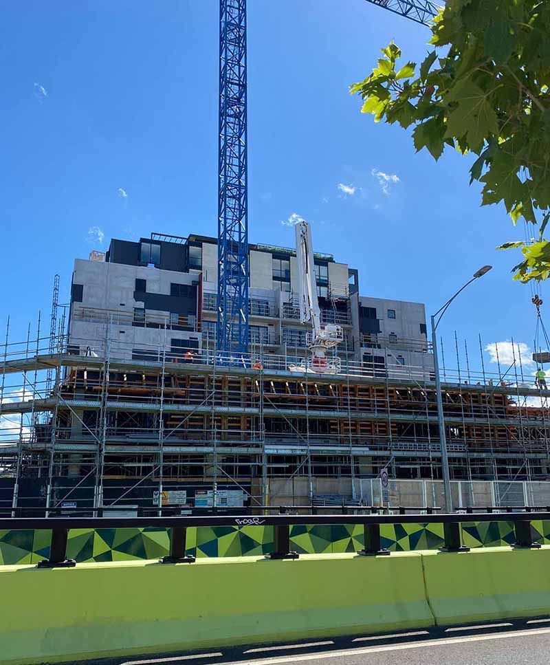 A large building under construction with a crane in the background