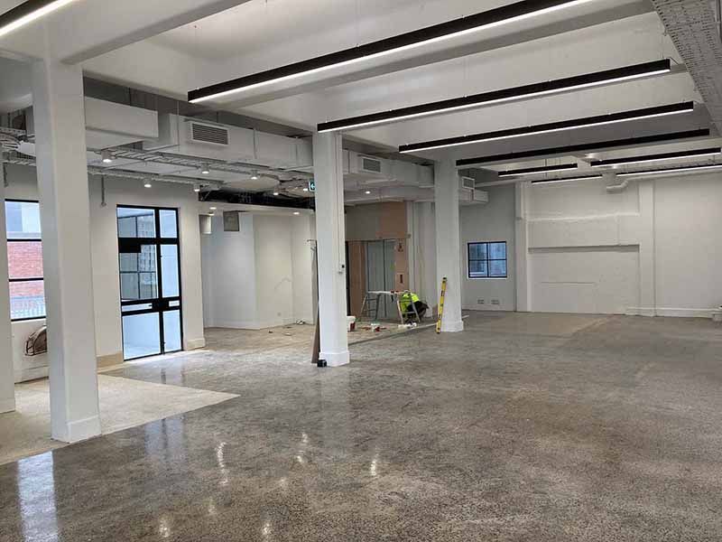 A large empty room with a concrete floor and white walls.