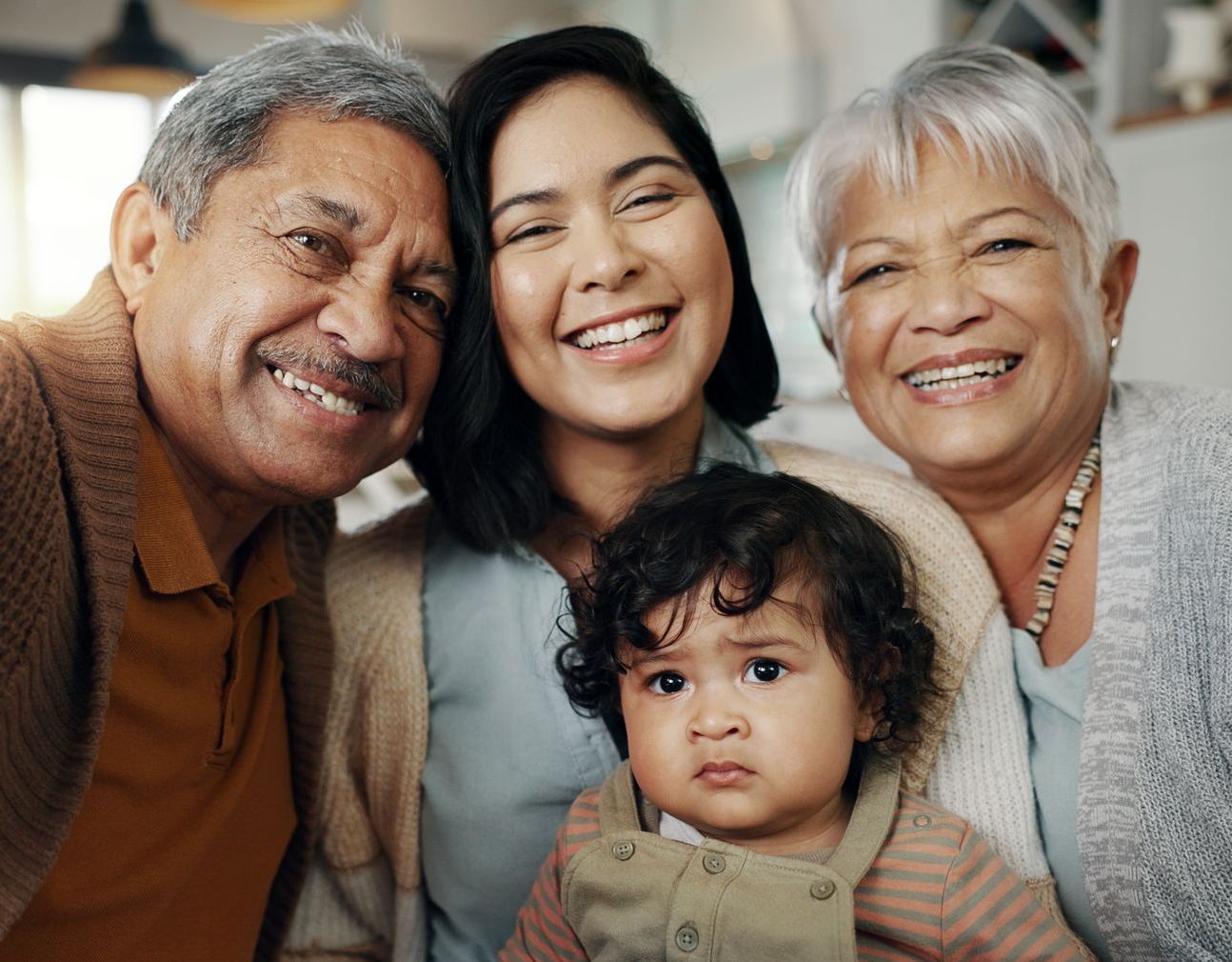 A family is posing for a picture with a baby.