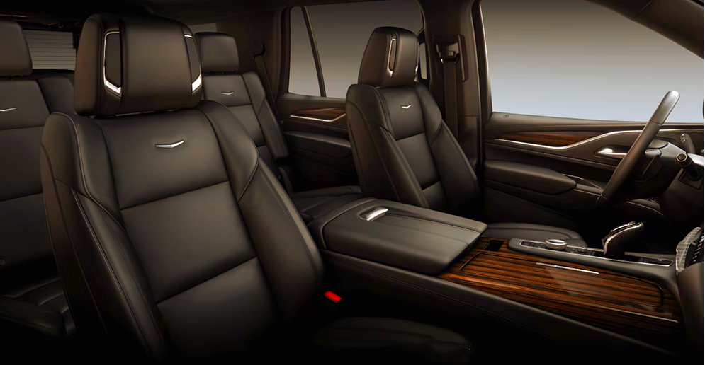 The interior of a car with black leather seats and wooden trim.