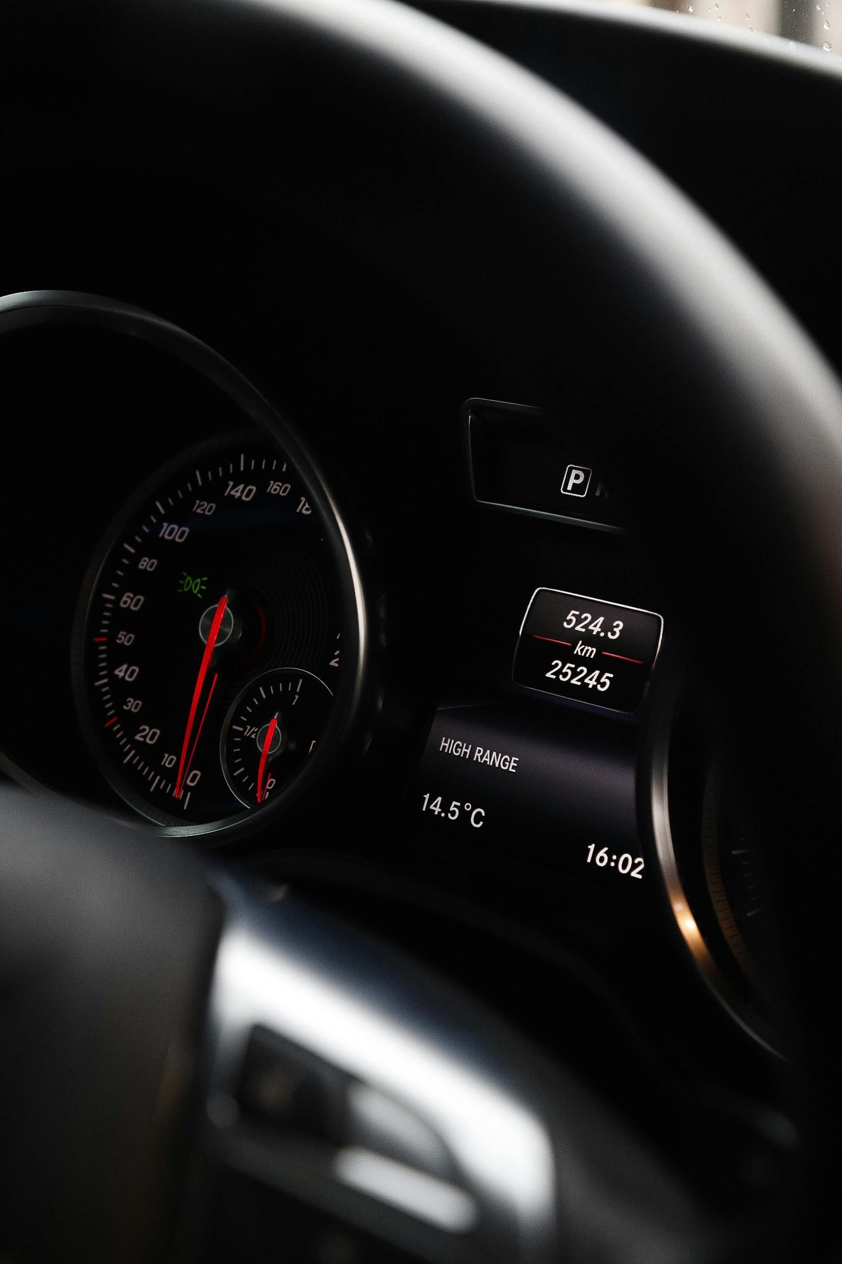 A close up of a car dashboard with a speedometer and a thermometer