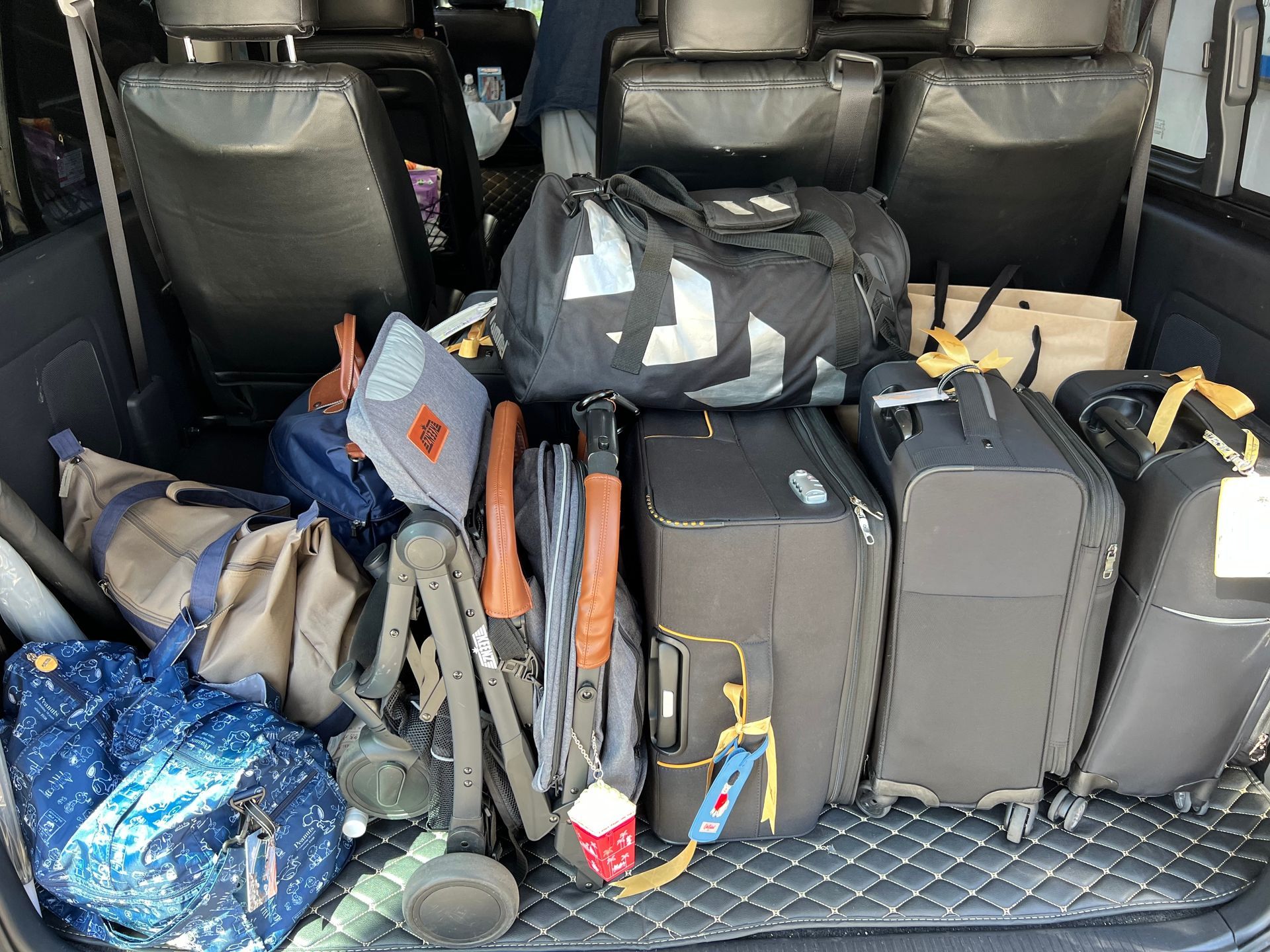 The trunk of a car is filled with luggage and bags.