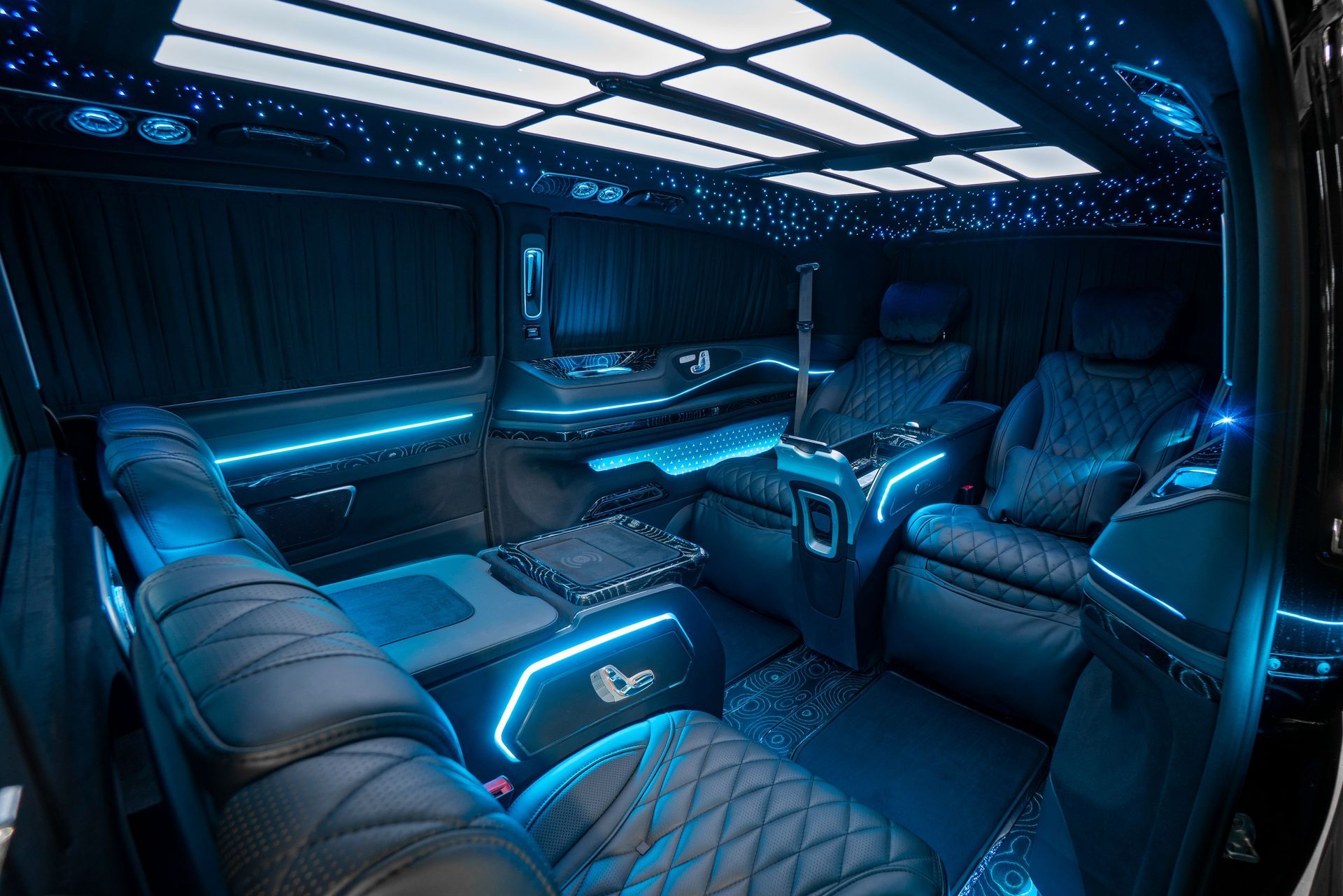 The interior of a mercedes benz van with blue lights on the ceiling.