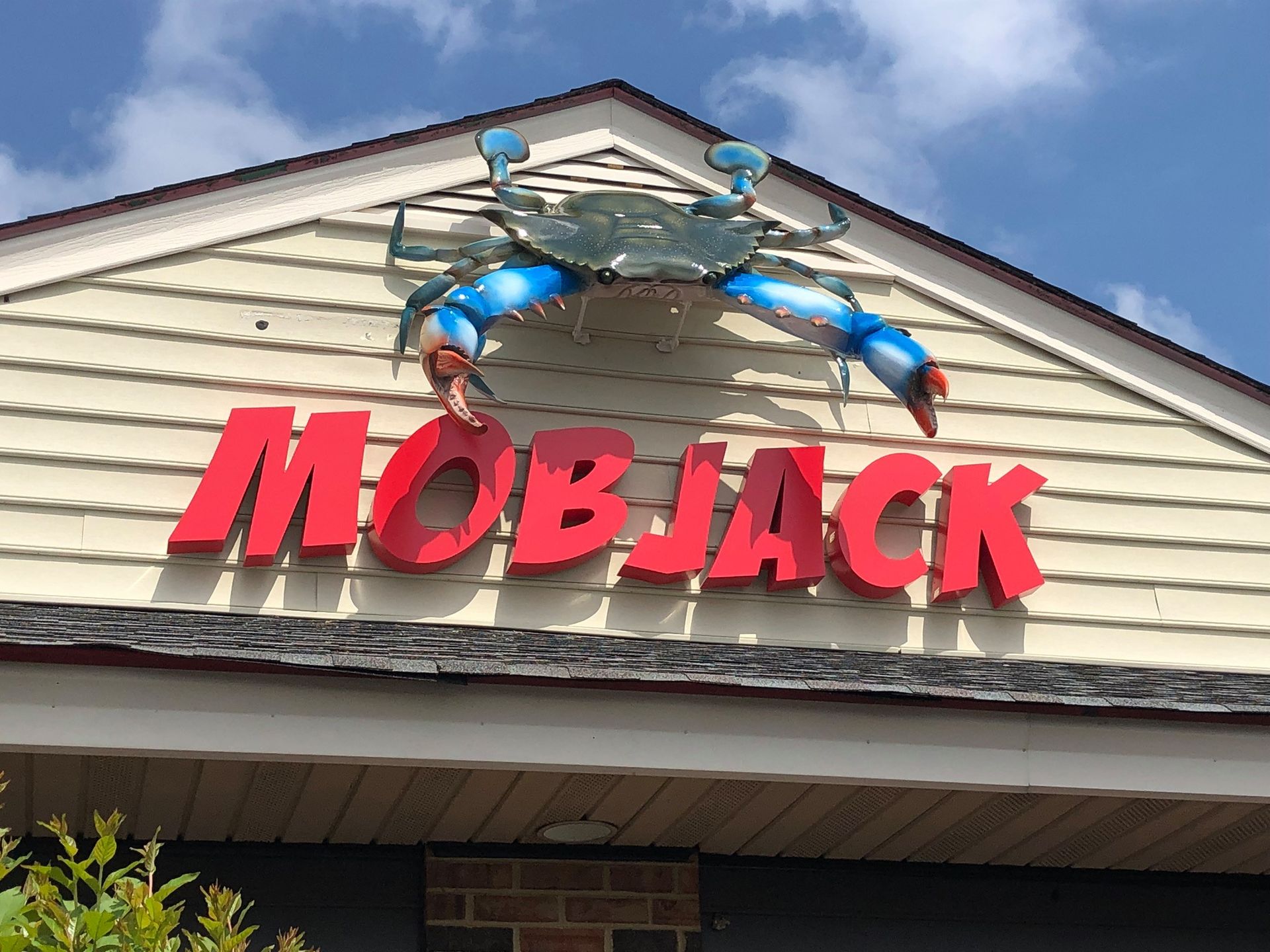 A sign for mobjack with a crab on top of it