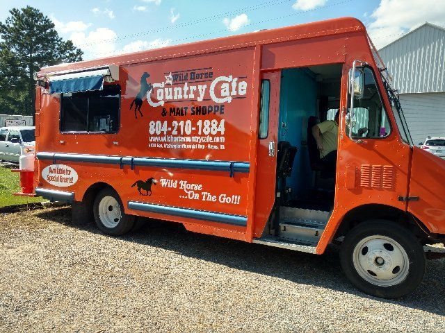 A country cafe food truck is parked in a gravel lot