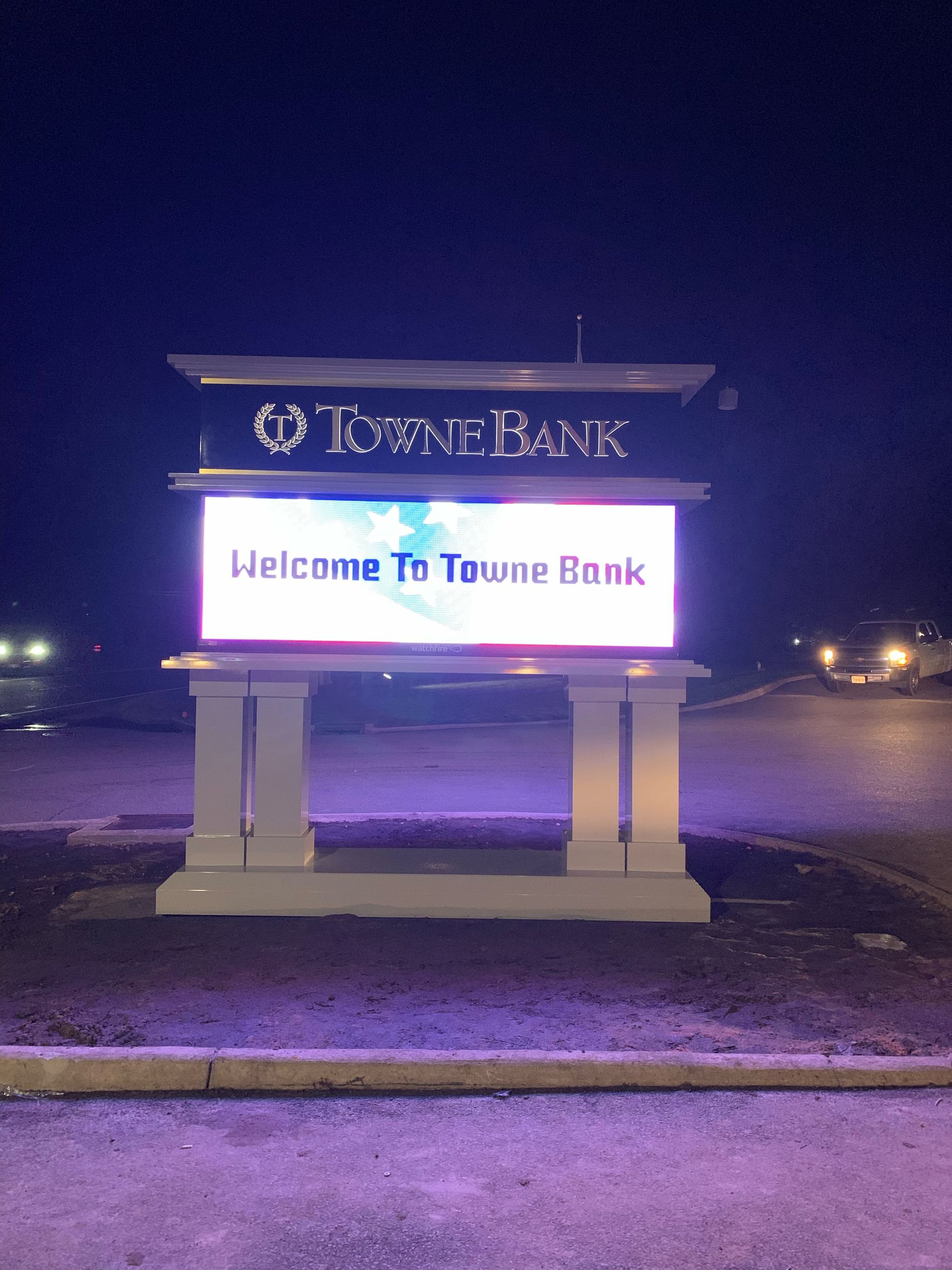A sign for towne bank is lit up at night