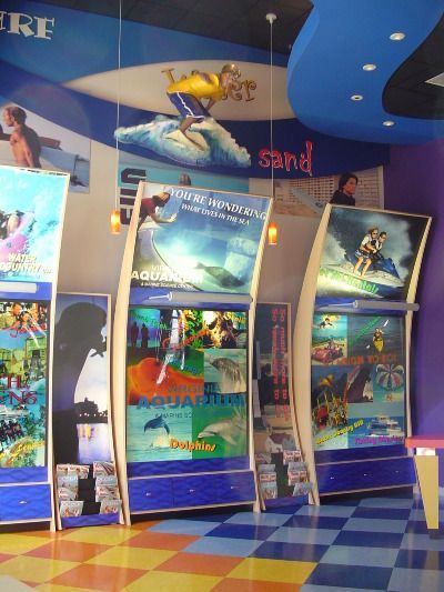 A row of arcade games with the word sand on the ceiling