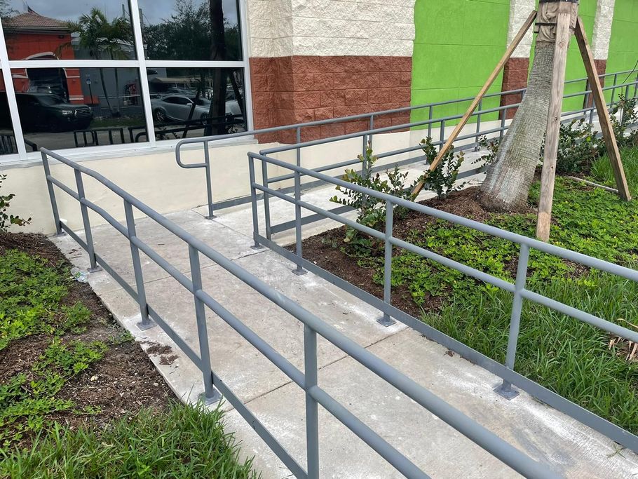 A ramp with a metal railing leading to a building.