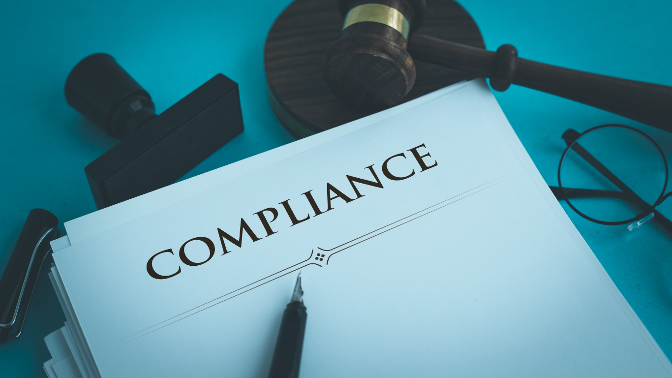 A piece of paper with the word compliance written on it.