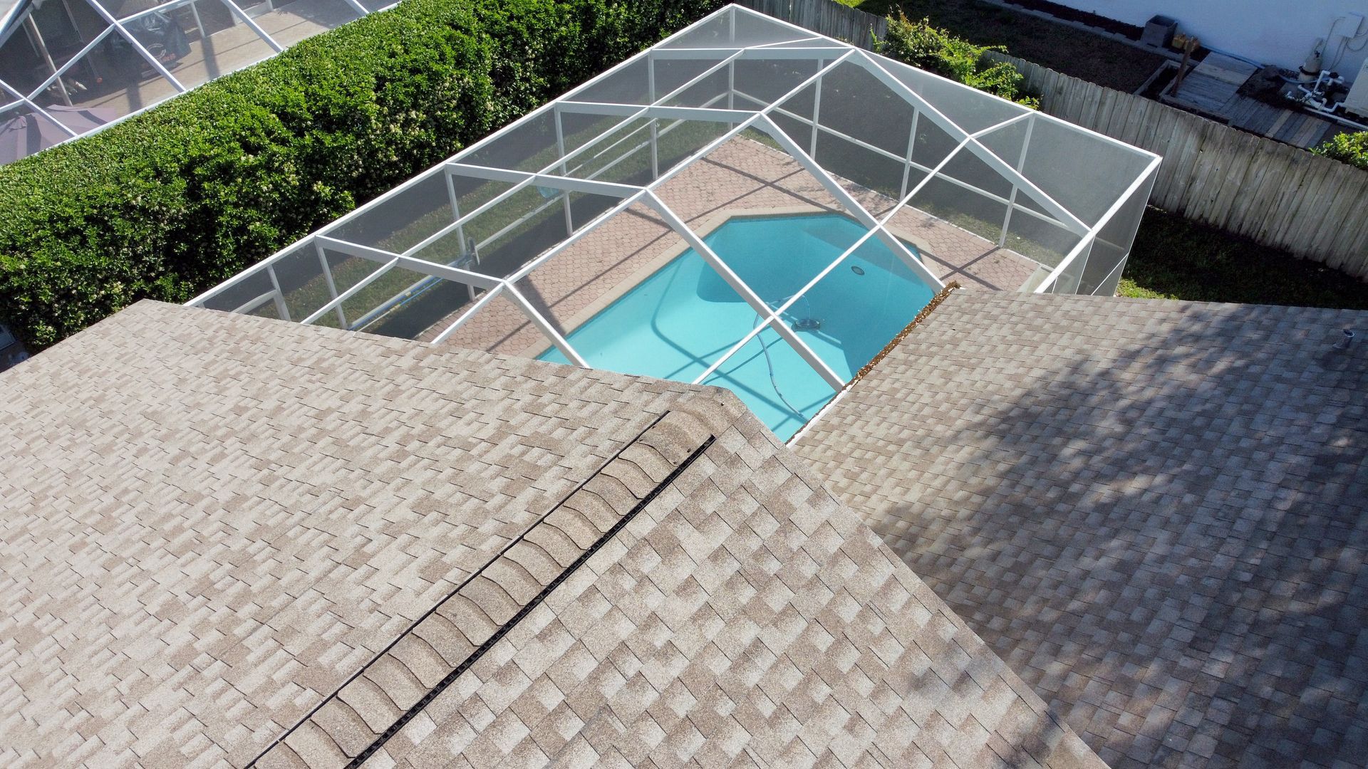 Aerial view of the screened pool enclosure behind the house. Aerial view of the screened pool enclosure behind the house.