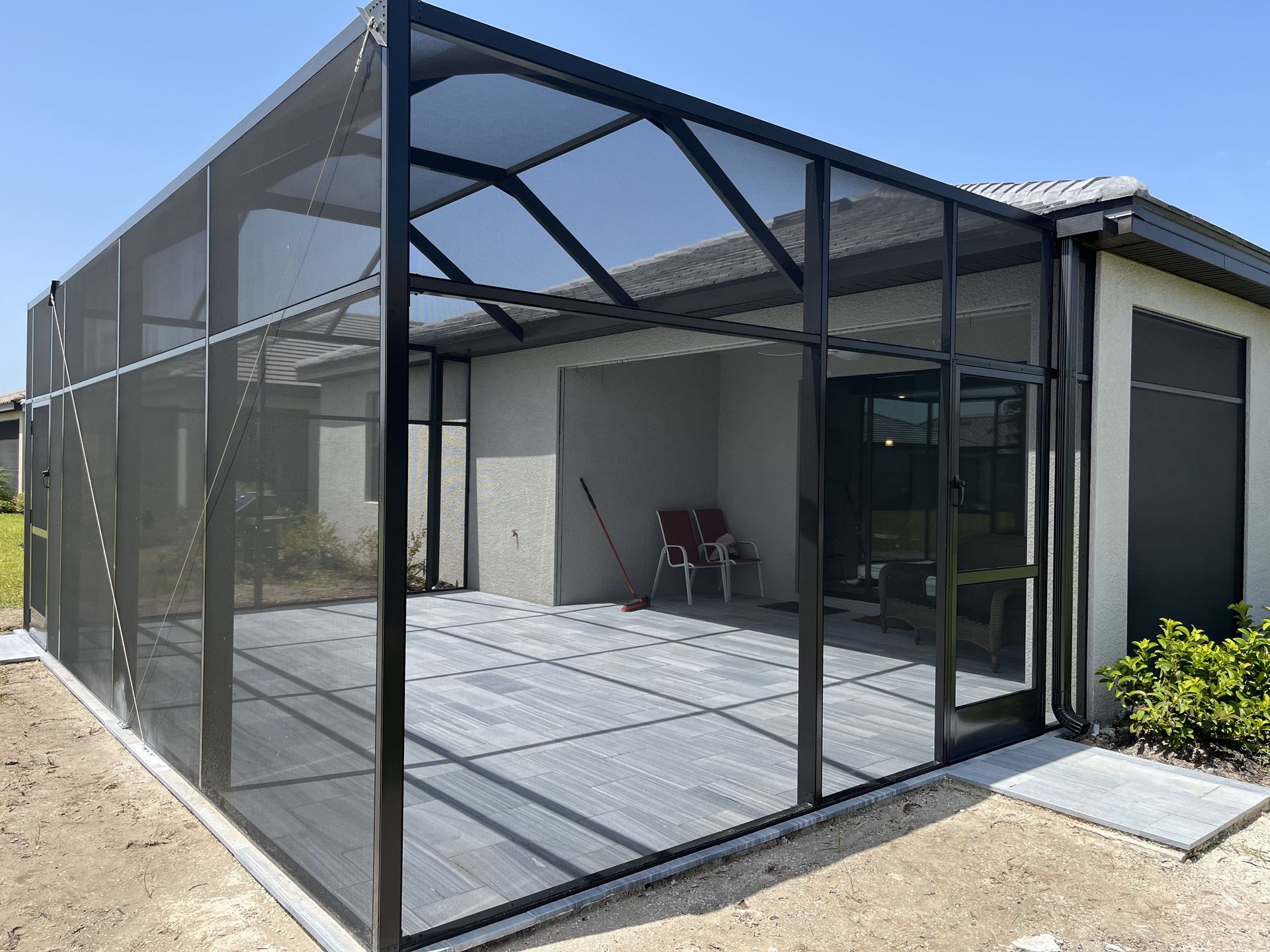 A Screened-in porch with a bench and chairs – Valrico, FL - Salco Screens