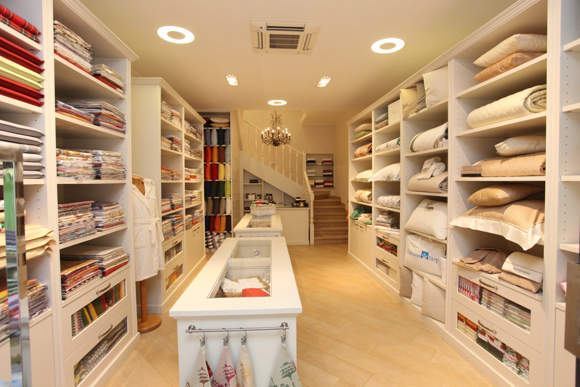 l'interno di punto vendita per biancheria con scaffali e tavolo bianco