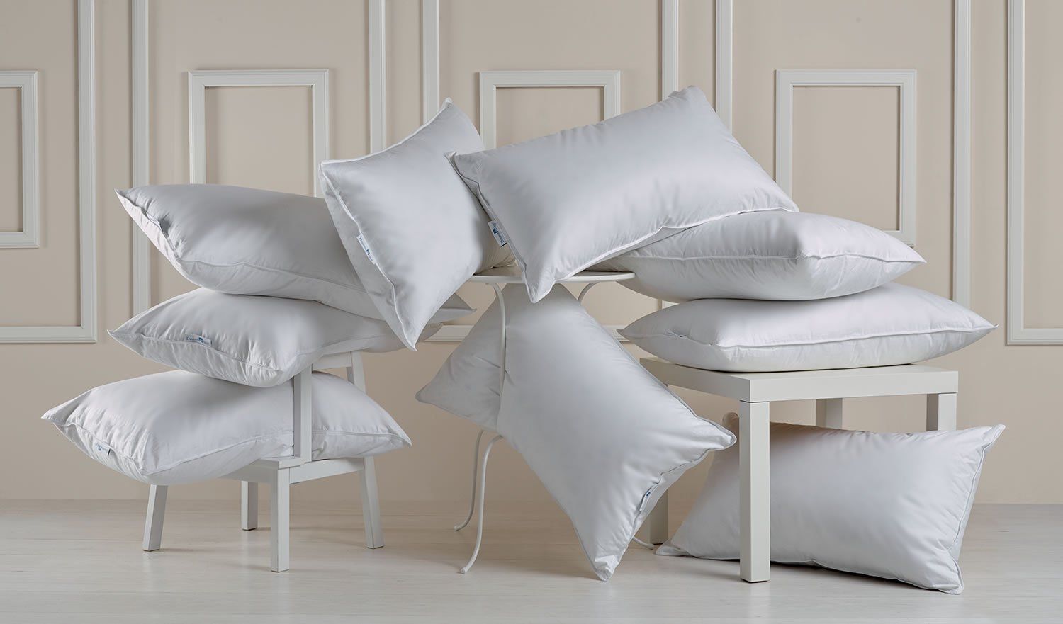 nove cuscini bianchi su due sedie in legno