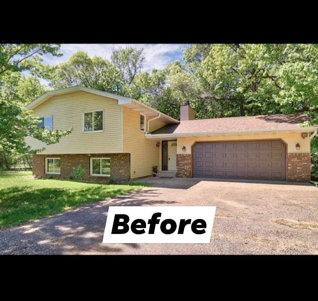 Two-story house with yellow siding and brick facade. Garage has brown doors. Trees in the background. 