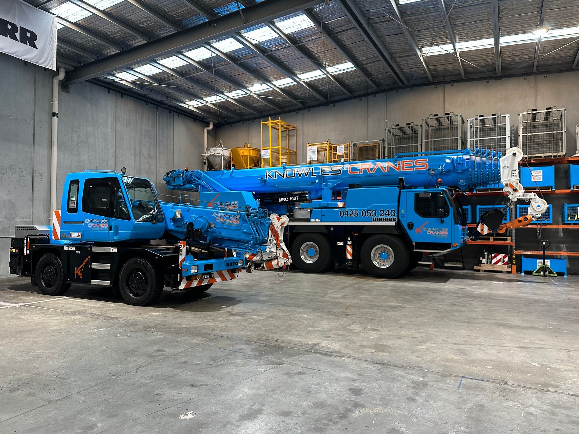 Franna and Liebherr cranes ready in warehouse for precision lifting operations