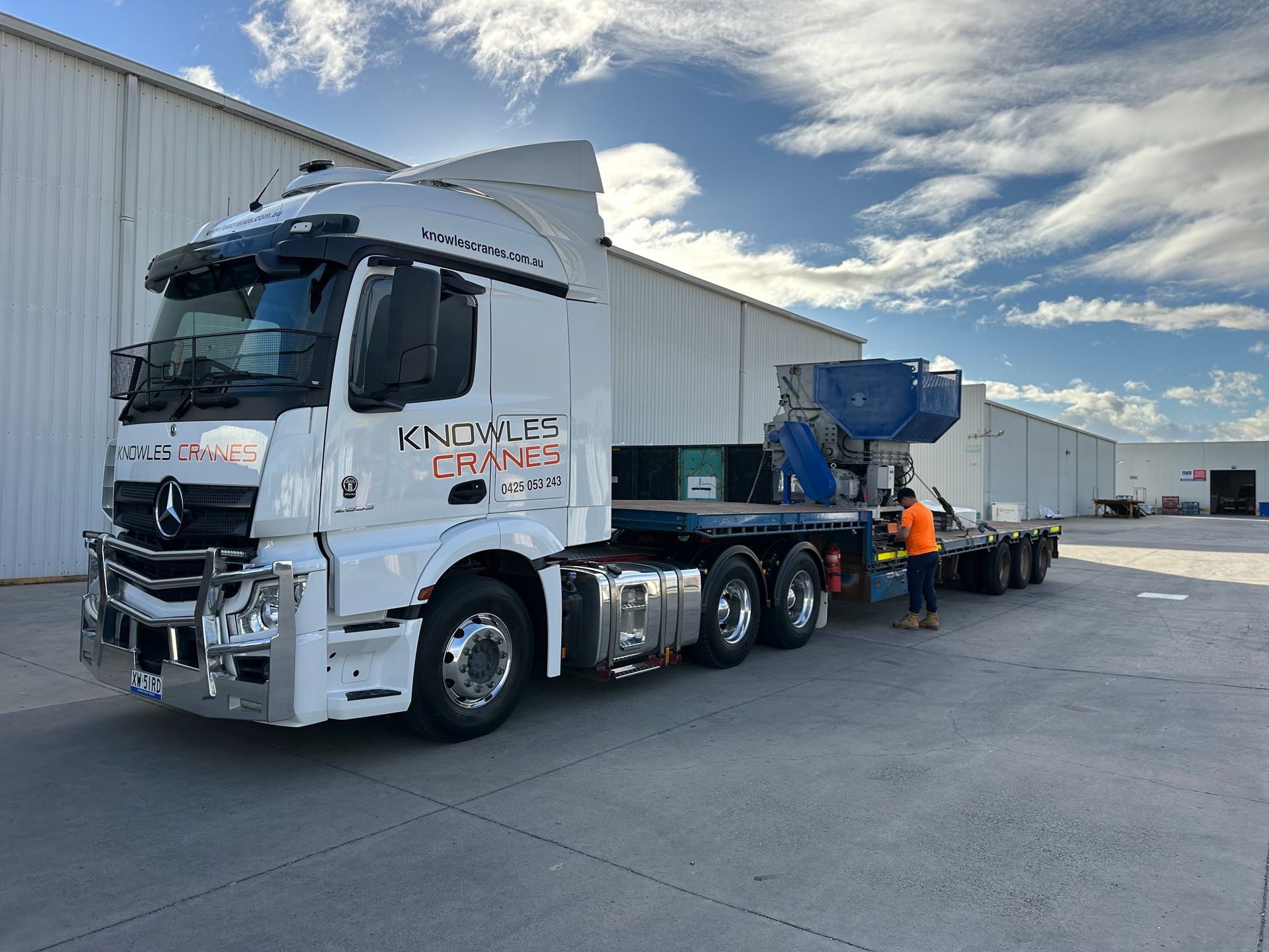 Specialist machinery loaded and secured on a flatbed truck for delivery