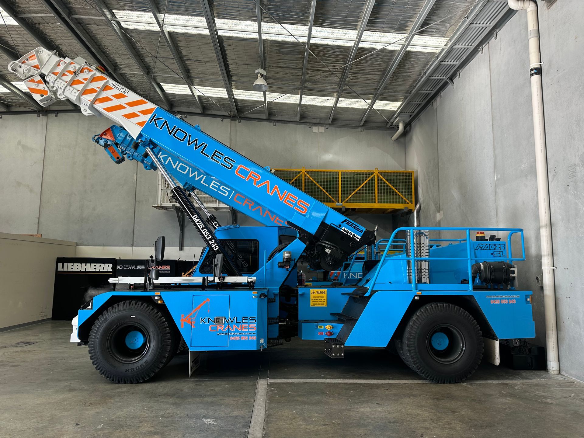 Franna MAC 25 crane parked indoors at Knowles Cranes facility with boom raised.