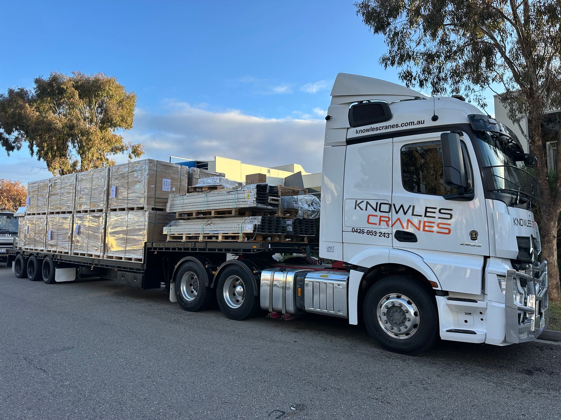 Knowles Cranes truck parked on roadside loaded with neatly stacked pallets.
Ask ChatGPT