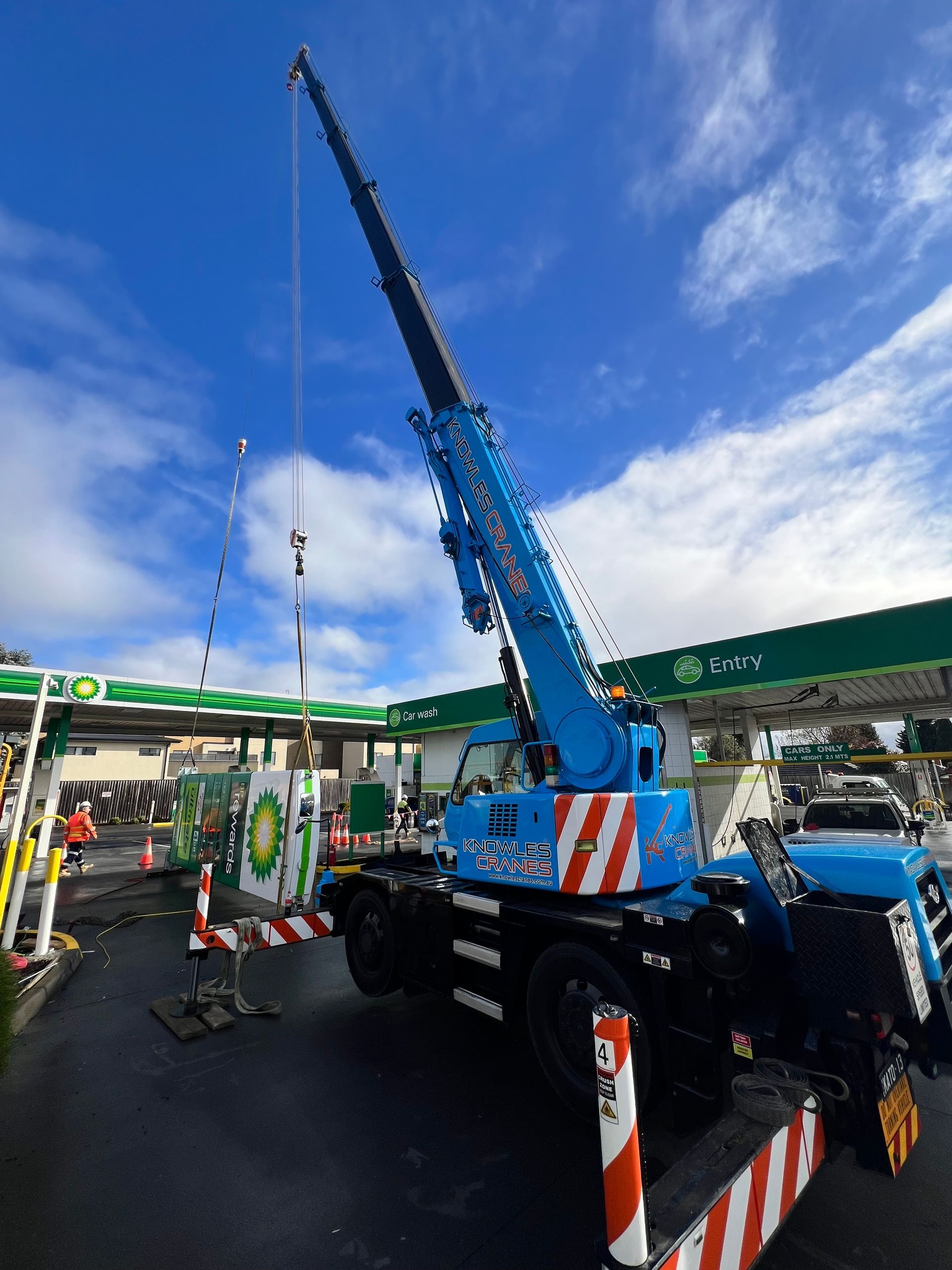 mobile crane lifting a huge signage