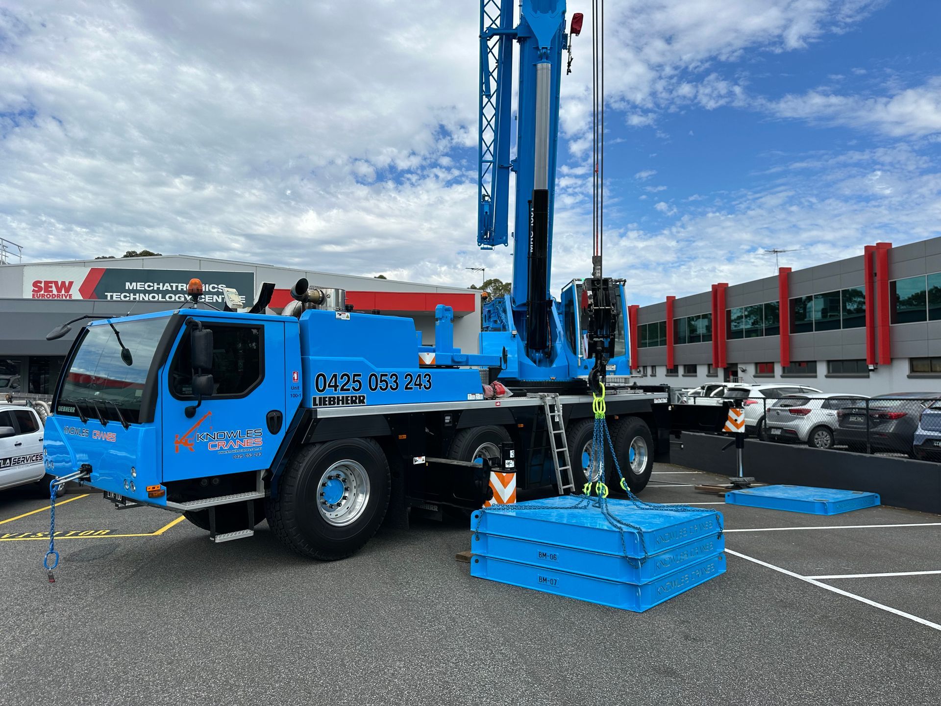 Knowles Cranes forklift carefully maneuvering a large stainless tank inside a facility with precision handling
