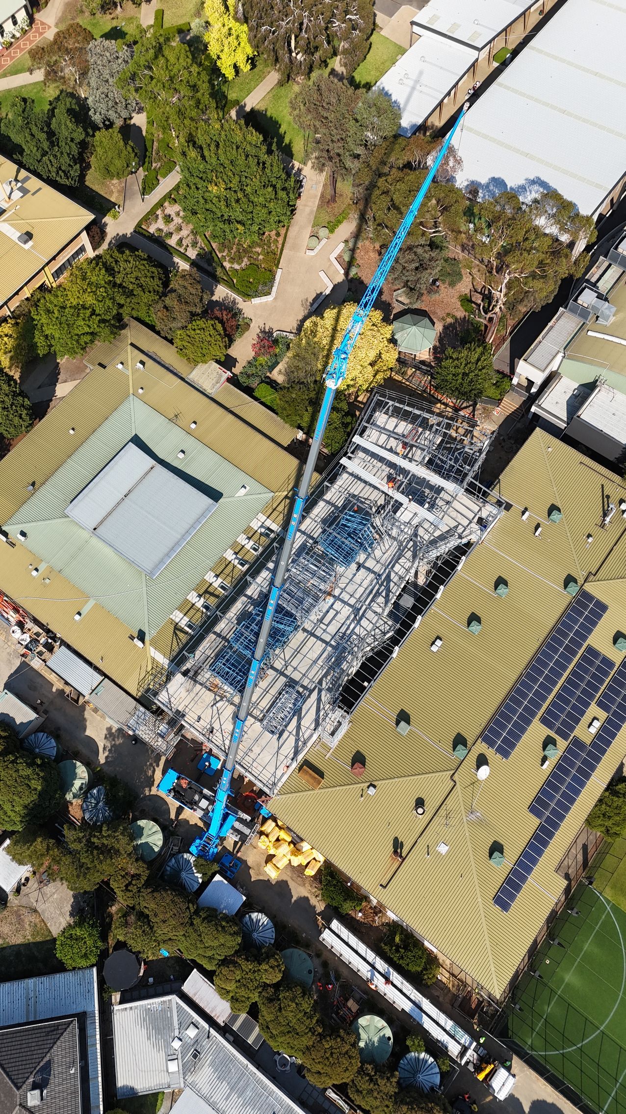 Precision lift across rooftops  Knowles Cranes navigating tight school grounds to install major structural steel.