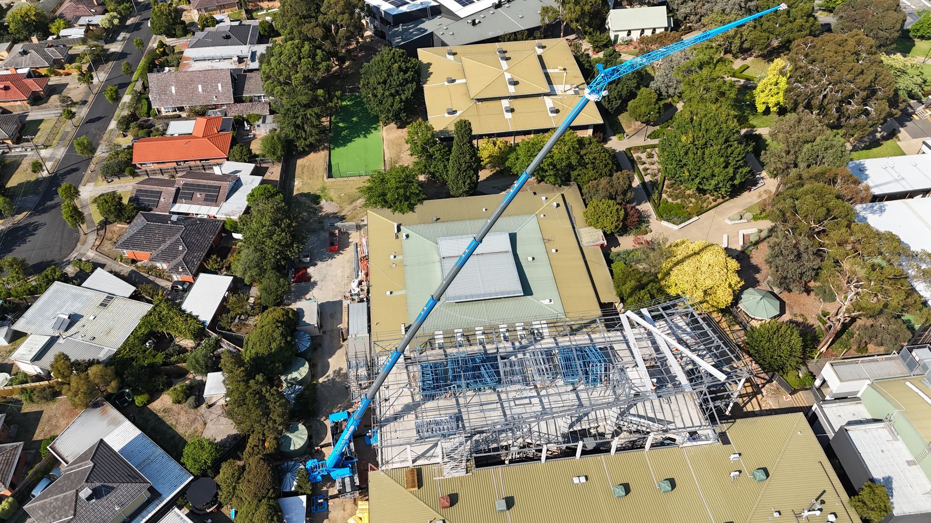 An aerial view of a building under construction in a residential area.
