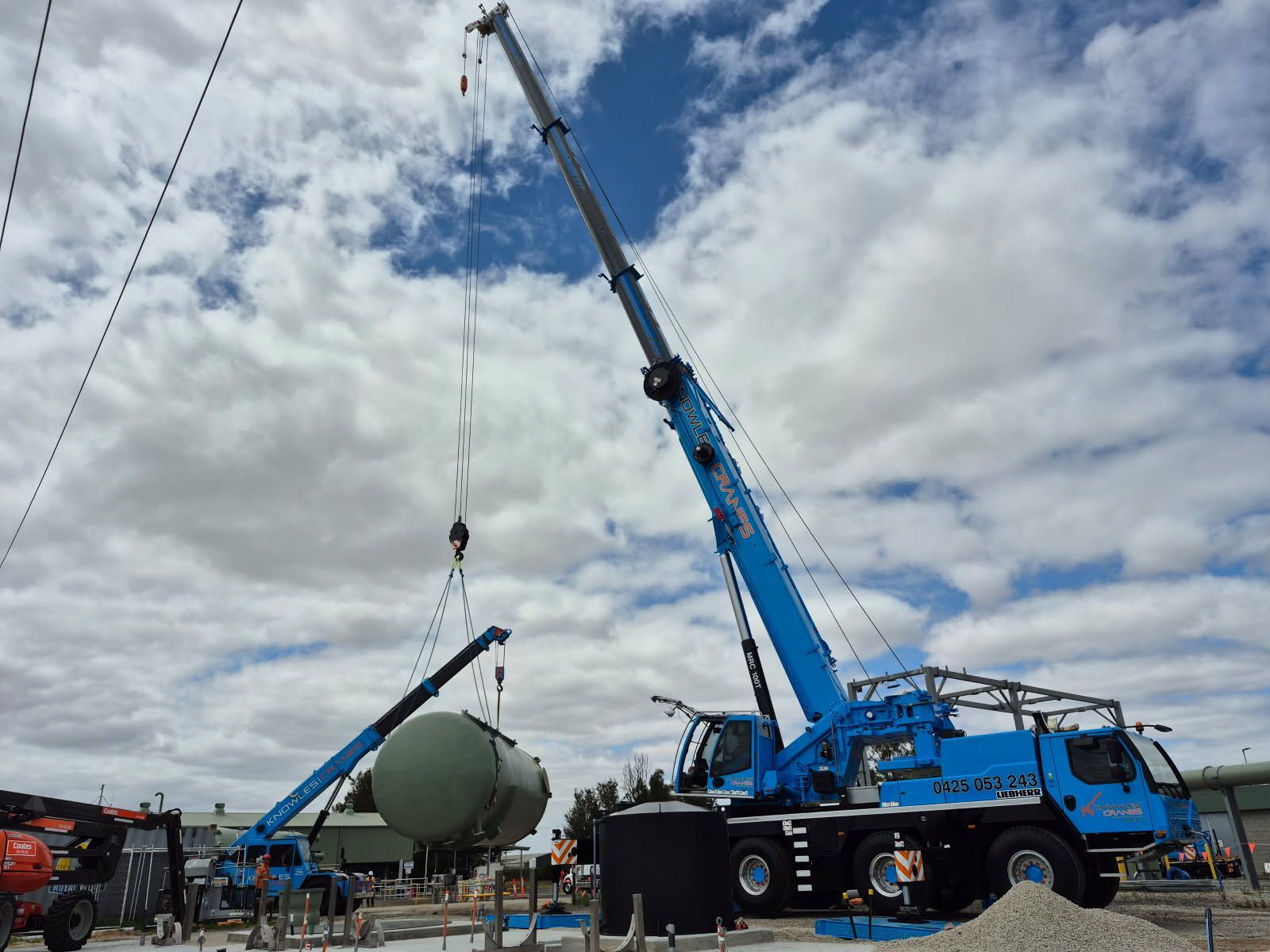 Dual crane lift in action, safely positioning industrial tanks with precision and power.