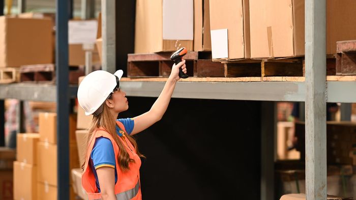 a woman in an orange vest and a white hard hat
