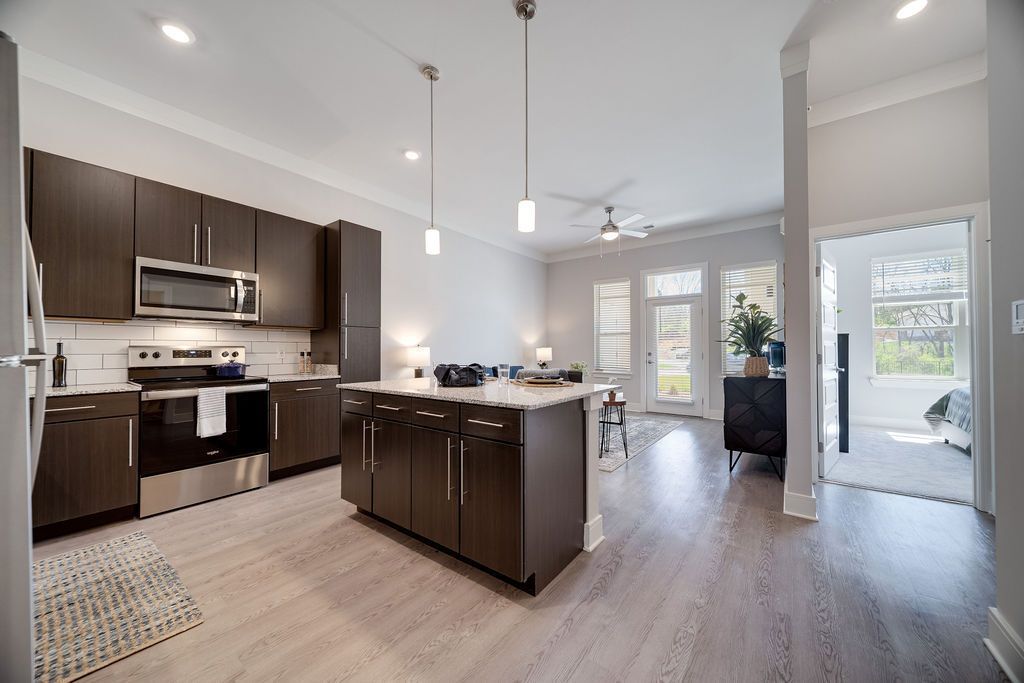 Open-concept kitchen with dark wood cabinets, stainless appliances, and a central island.