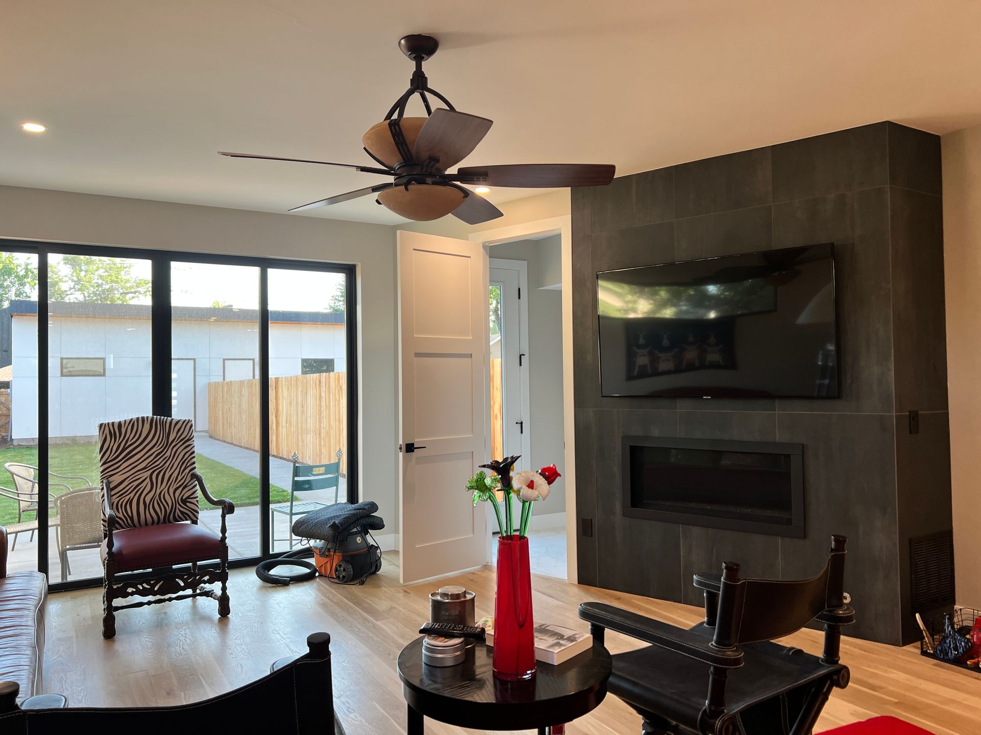 A living room with a ceiling fan and a fireplace.