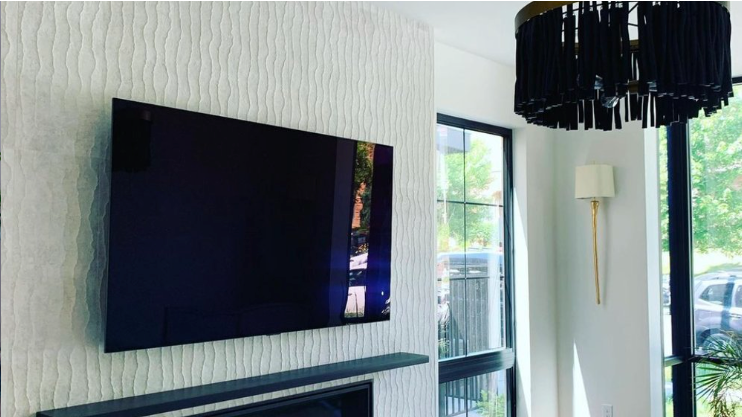 A living room with a flat screen tv mounted on the wall.