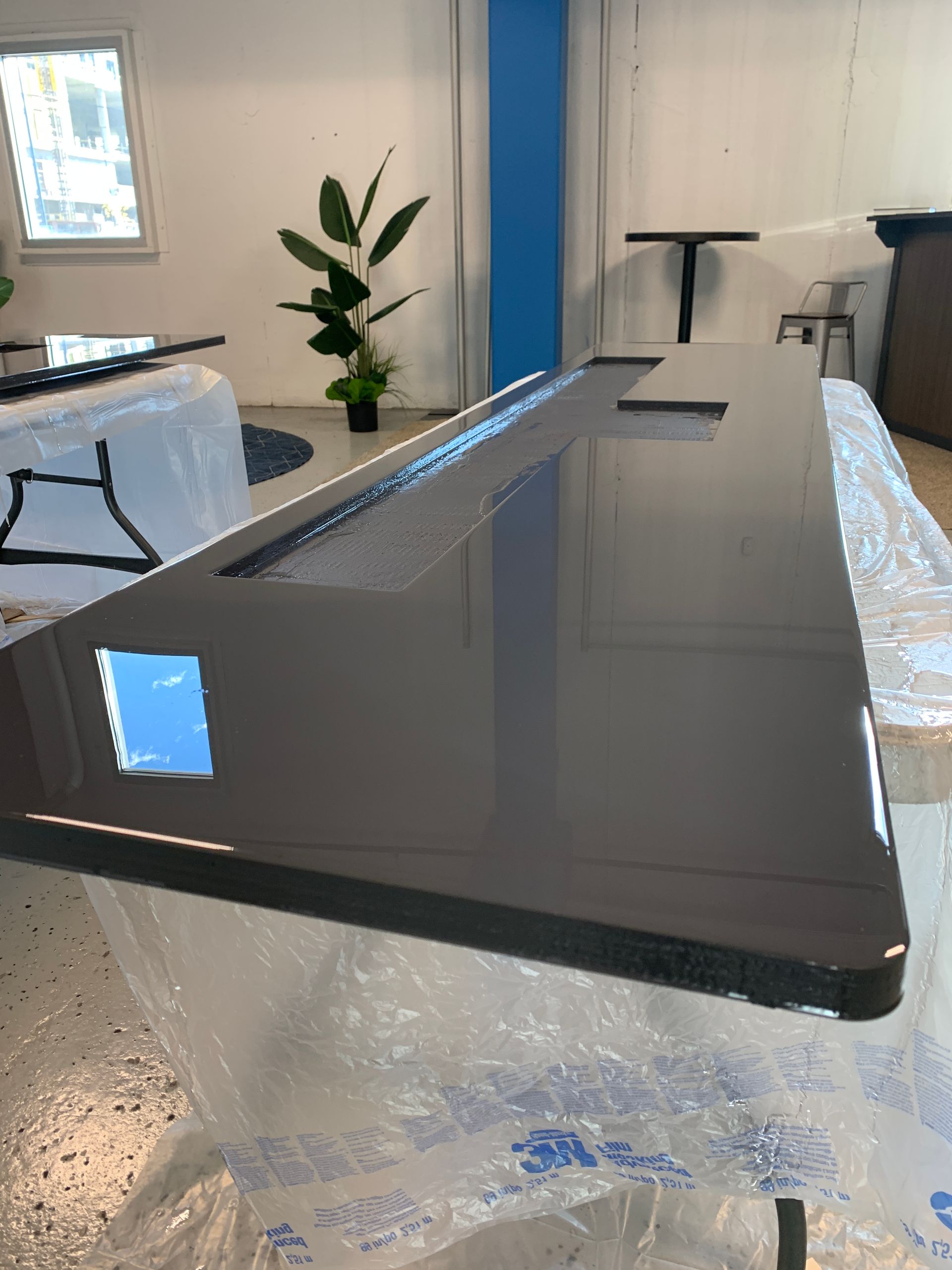 A black table is sitting on top of a plastic bag in a room.