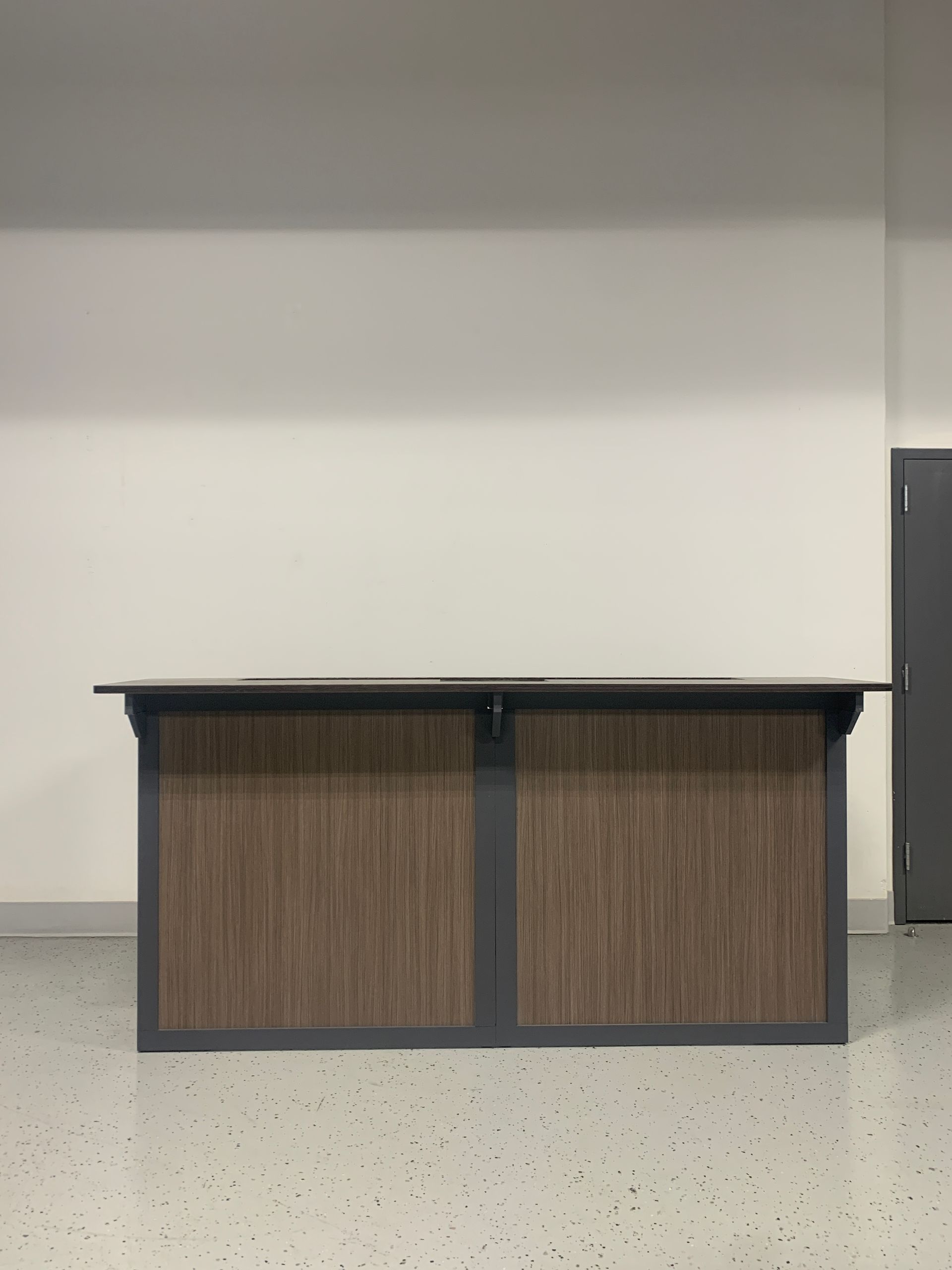 A wooden table is sitting in front of a white wall in a room.