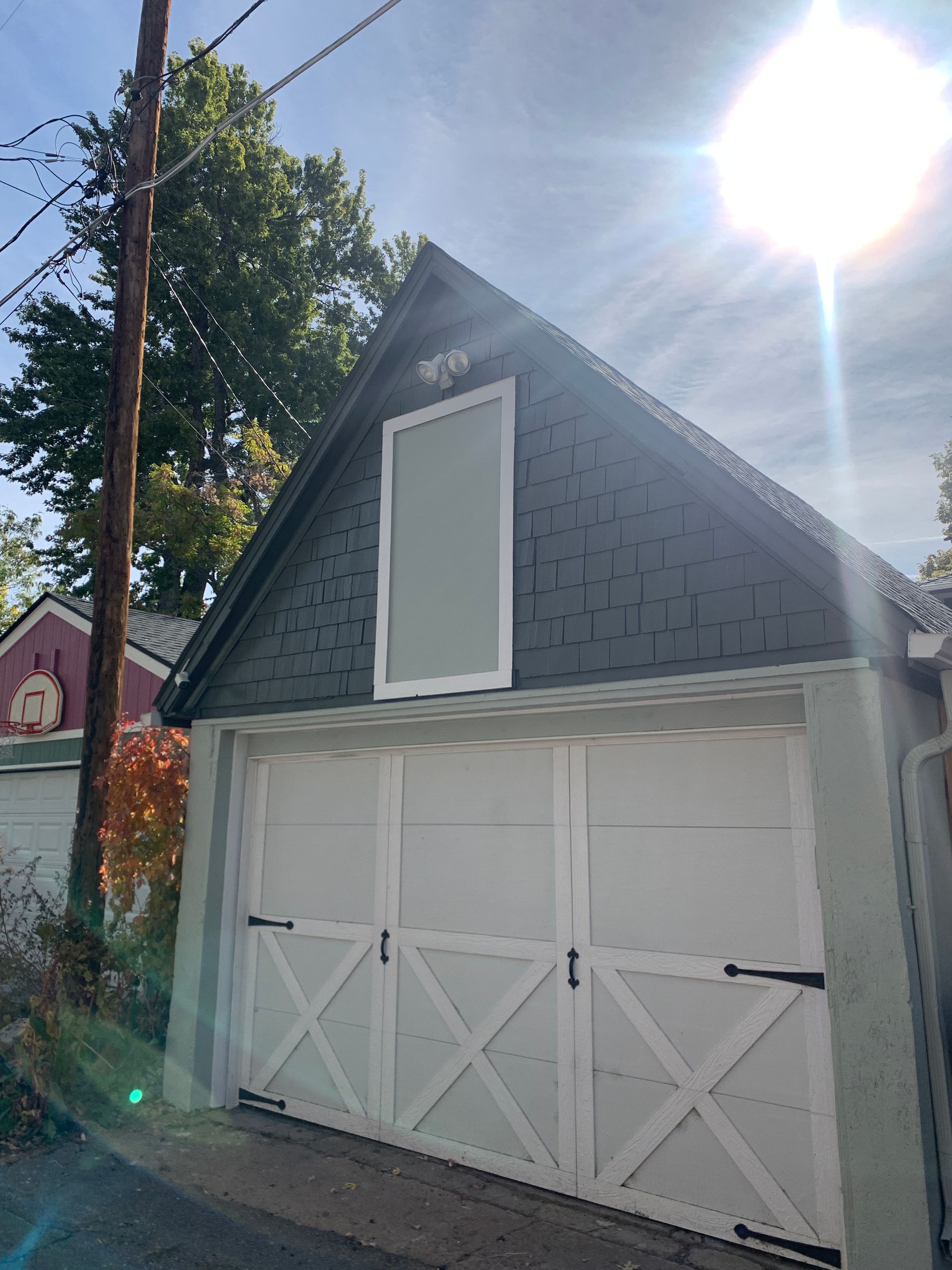 A garage with a black roof and white doors.