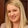 A woman with long blonde hair is smiling for the camera.