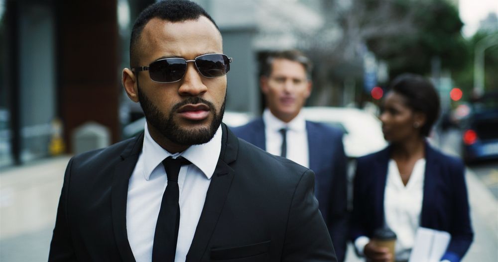 A man in a suit and tie is walking down the street with two other people.