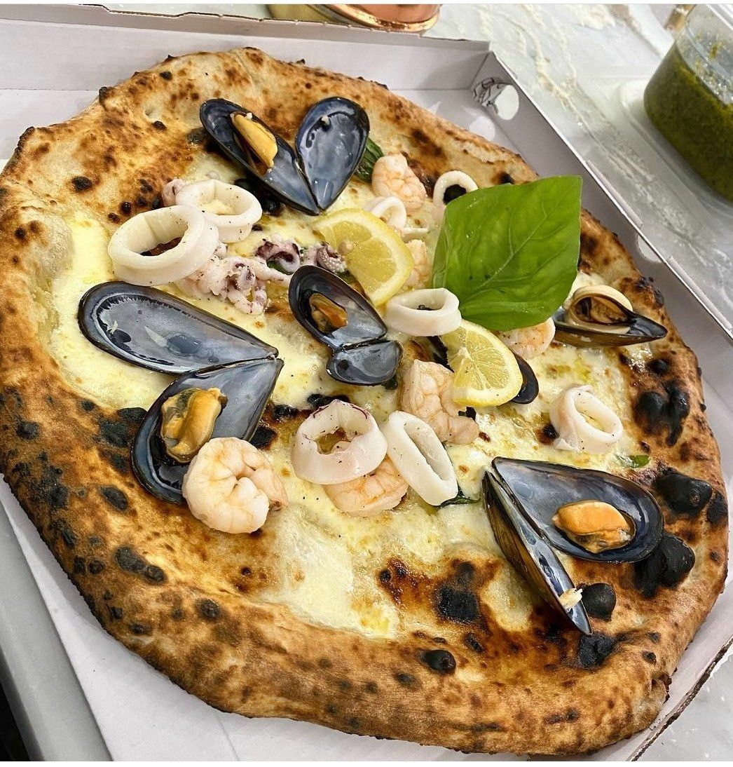 pizza con frutti di mare della pizzeria napoletana con forno a legna a Milano