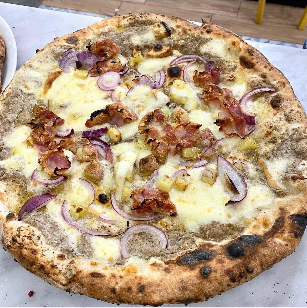 pizza con pancetta e cipolle della pizzeria napoletana con forno a legna a Milano