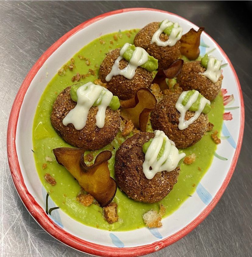 Un piatto di cibo con una salsa verde sopra