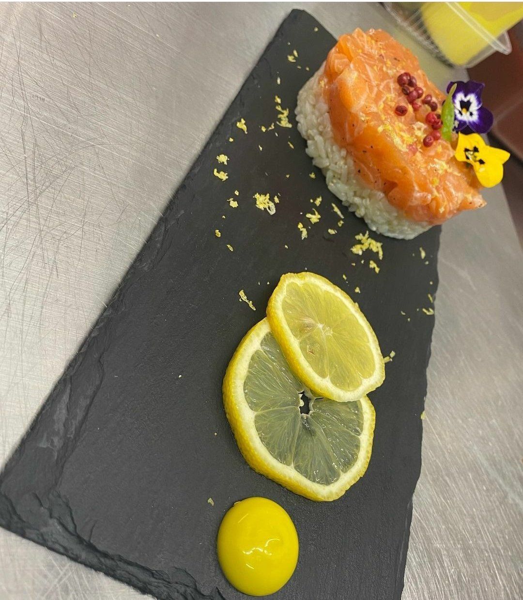 Un piatto di cibo con fette di limone e una salsa gialla