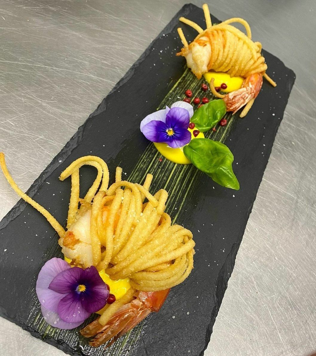 Un piatto di cibo con noodles e gamberi su un tavolo