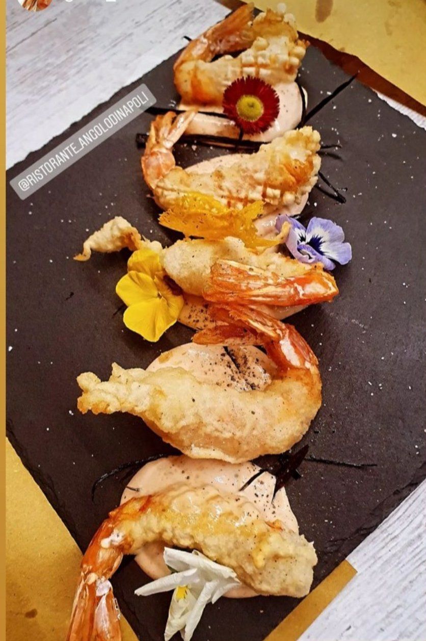 Un primo piano di un piatto di gamberi con fiori sopra