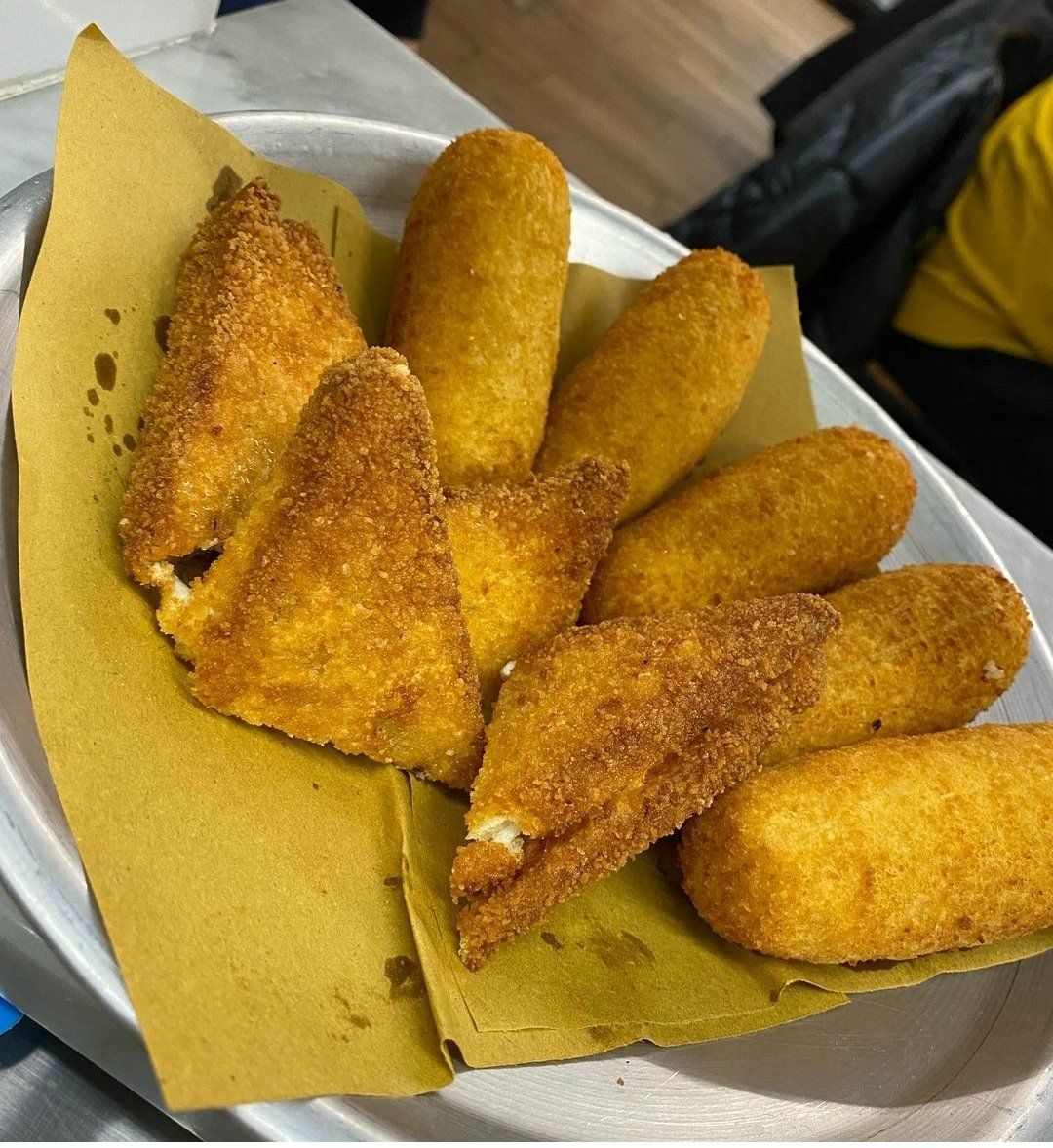 Un piatto bianco con del cibo fritto su un pezzo di carta