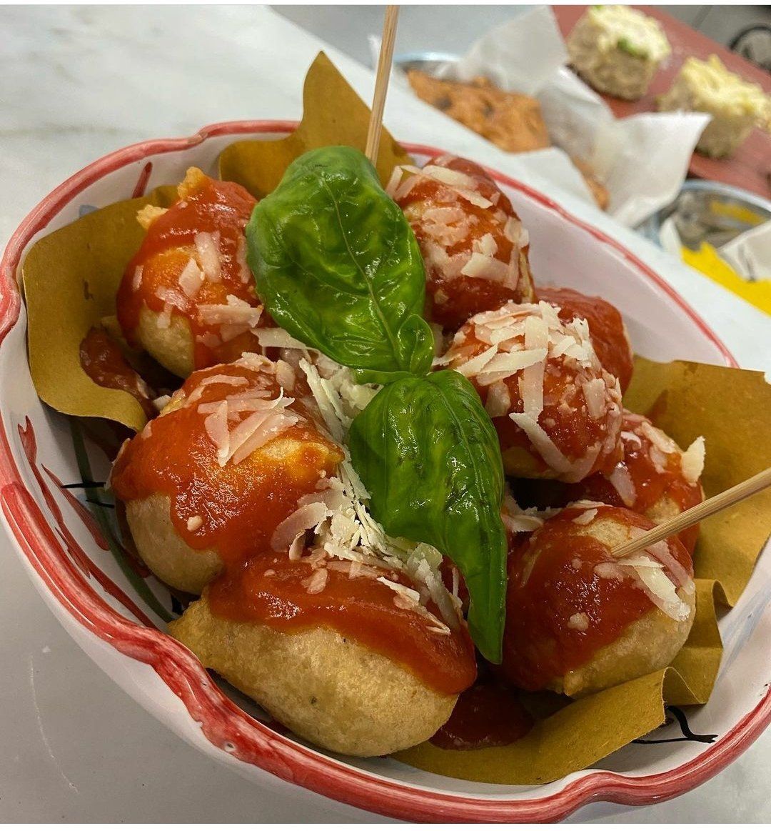 Una ciotola di cibo con salsa di pomodoro e basilico su bastoncini