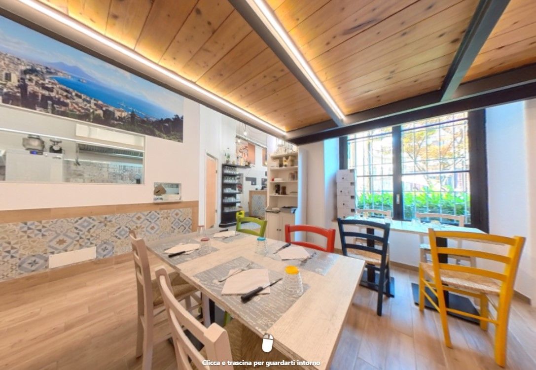 Un ristorante con tavoli, sedie e soffitto in legno.