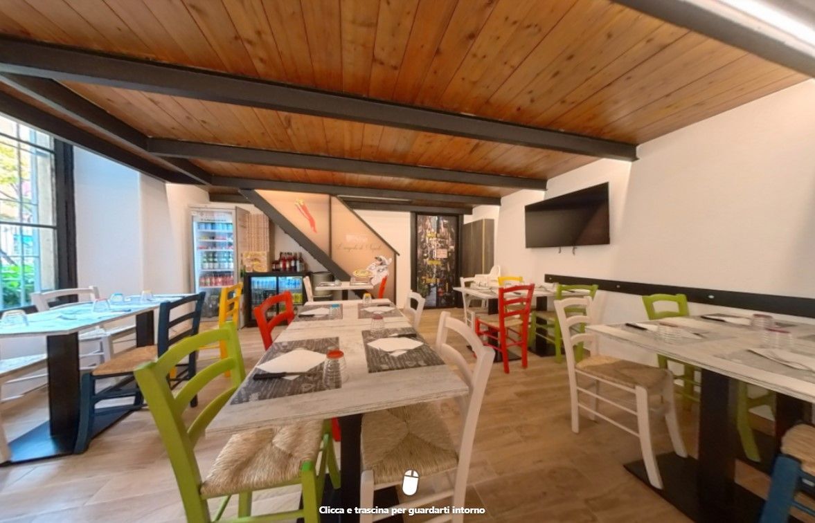 Un ristorante con tavoli e sedie e un soffitto in legno